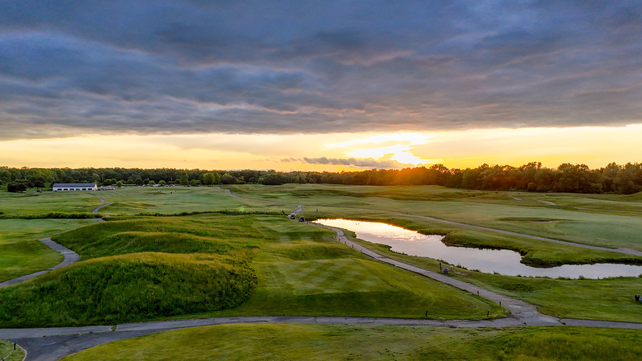 Sunset over the eighteenth with storm clouds breaking above the water